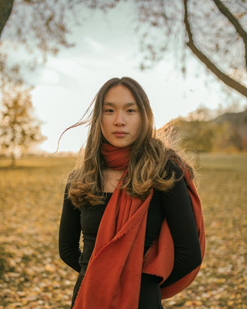 Woman with Dyed Hair in Red Scarf Standing in Meadow