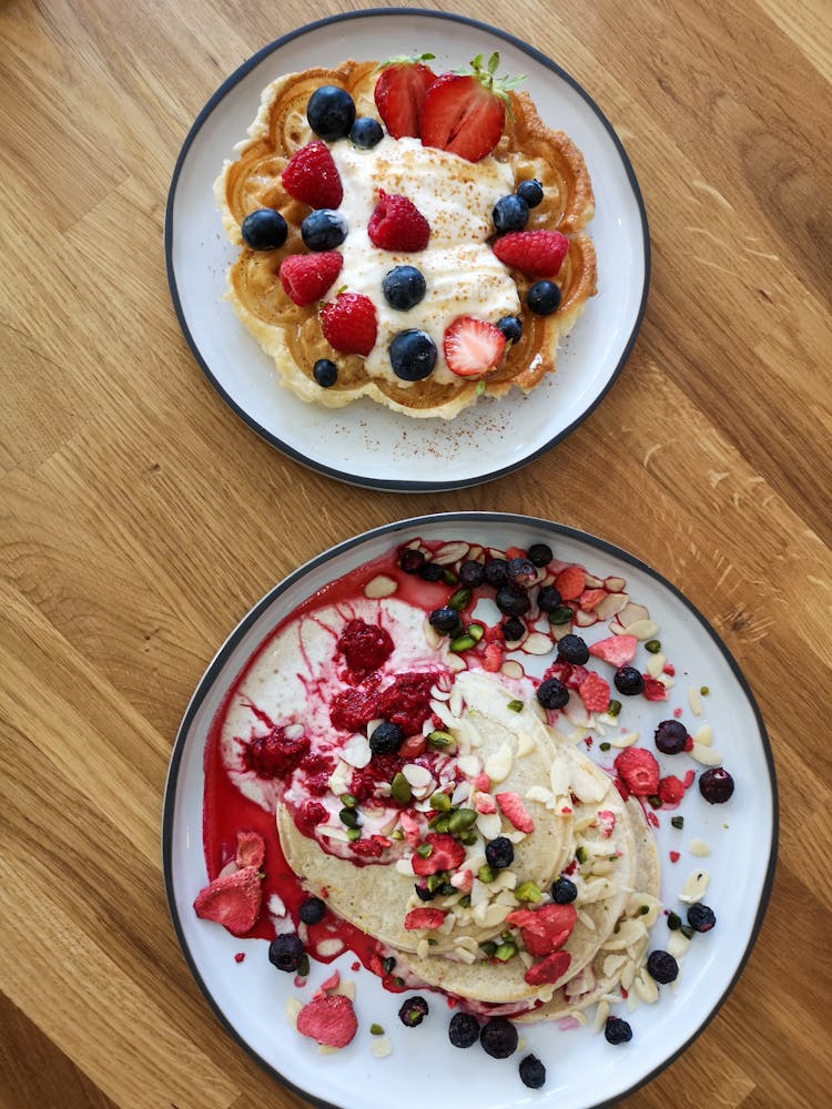 Waffles And Pancakes With Fresh Berries On Plates