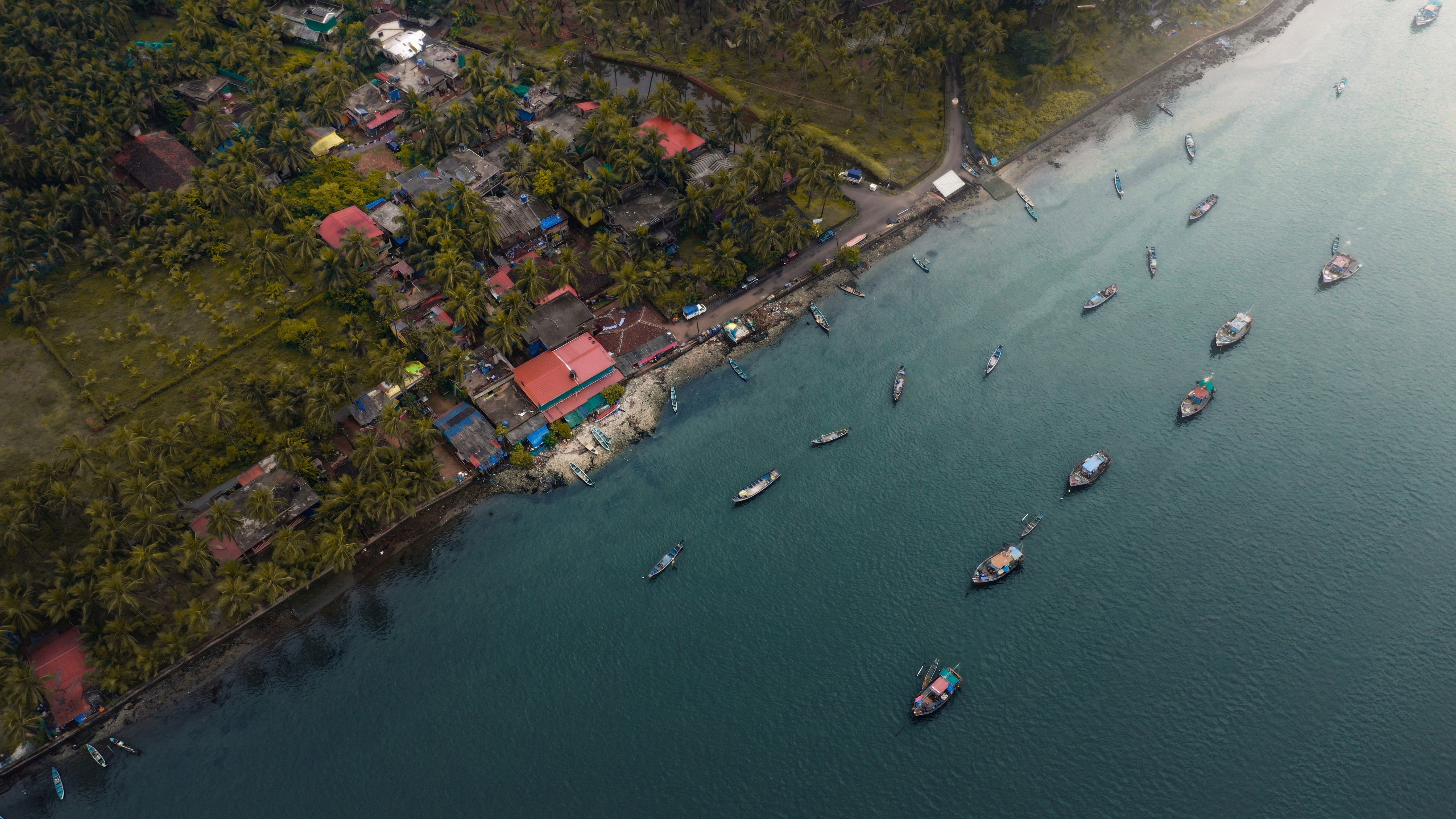 Fishing boats and low houses at Mahim koliwada with the causeway bridge behind