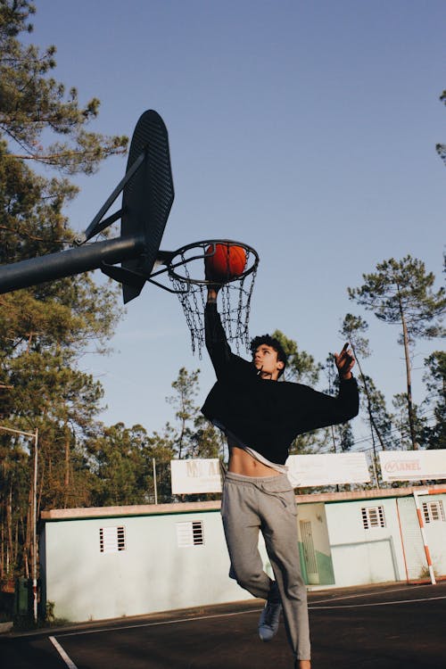 A Man Dunking a Ball into the Hoop