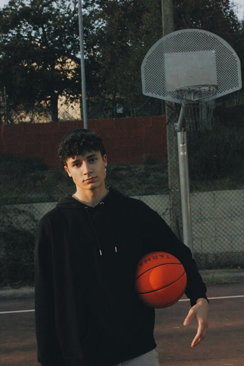 Man in Black Jacket Holding a Ball