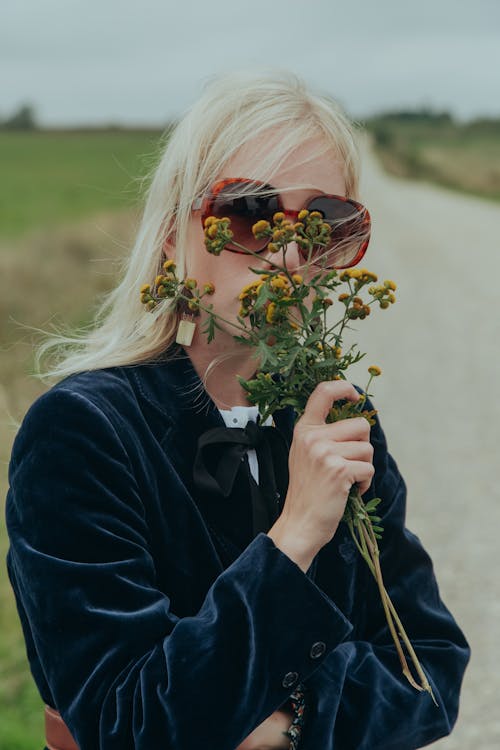 Woman Wearing a Blazer Holding Wild Flowers