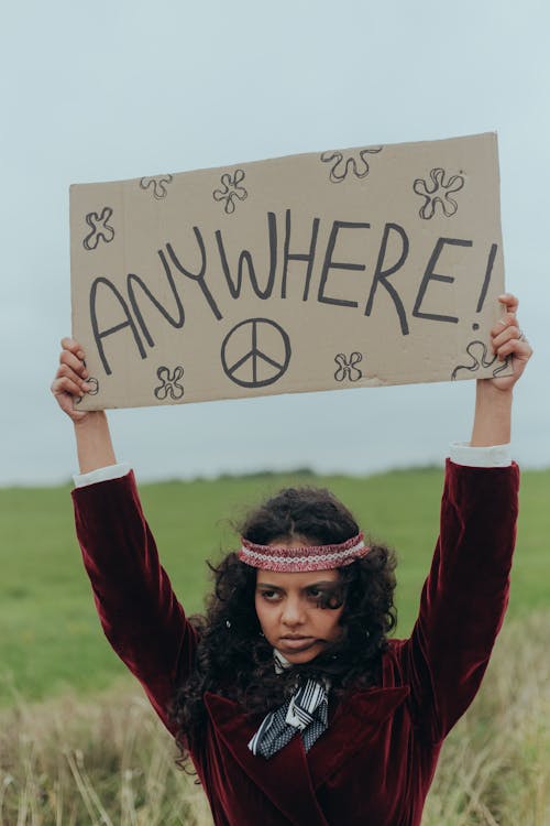 Woman Raising a Poster with the Word Anywhere