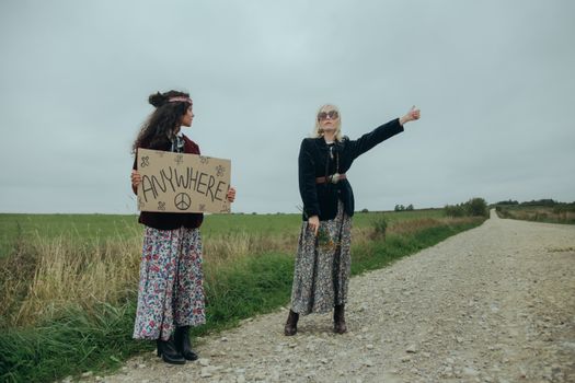 Women Hitchhiking on an Unpaved Road