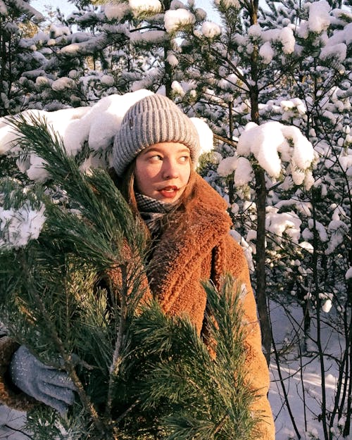 Free Woman in Brown Coat Holding a Pine Tree Stock Photo