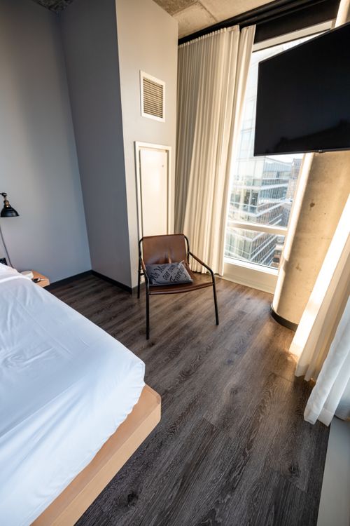 Free A sleek modern bedroom with stylish decor and a city view. Ideal for lifestyle and interior design themes. Stock Photo
