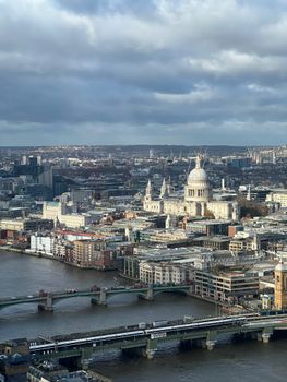 Captivating aerial view of London featuring the iconic St. Paul's Cathedral and surrounding cityscape beneath dramatic clouds.