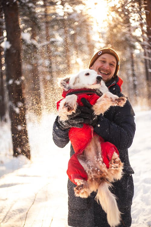 Man Carrying a Pet While Standing on Snow