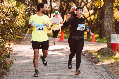 Free Energetic group of diverse runners enjoying a vibrant outdoor race event. Stock Photo