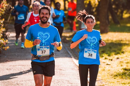 Man and Woman in Blue Shirts Jogging Together