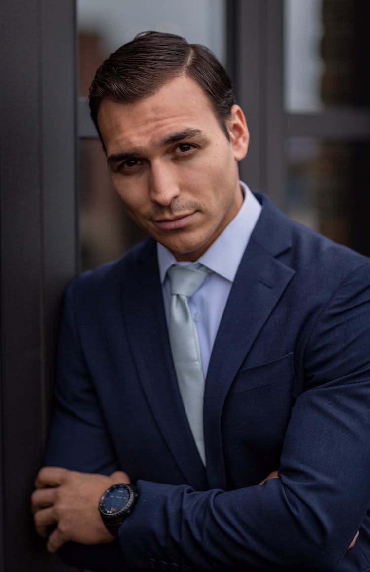 Corporate Businessman In Suit And Tie Standing By Window