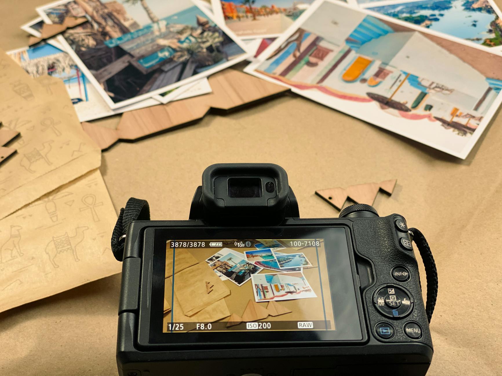 Camera focusing on various travel postcards arranged on a table, showcasing vibrant images.