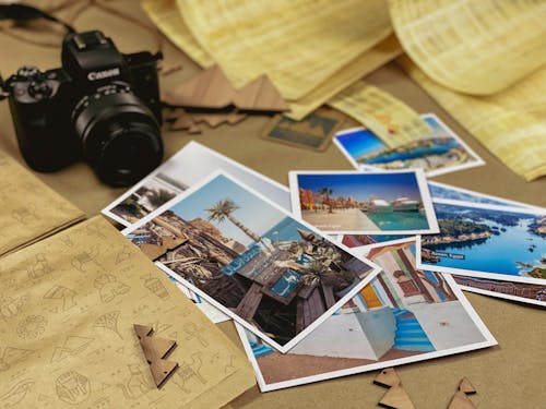 Postcards from Vacation and a Camera on Brown Paper 