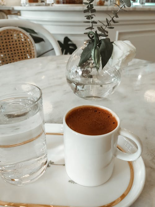 White Ceramic Mug with Hot Chocolate Drink Beside a Glass of Water on a Platter