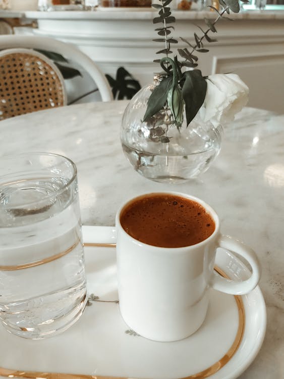 White Ceramic Mug with Hot Chocolate Drink Beside a Glass of Water on a Platter