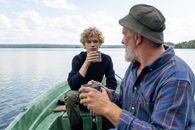 Grandfather and Grandson Having Tea on Boat Ride on Lake