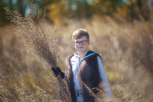 Young Boy Holding Dried Grass