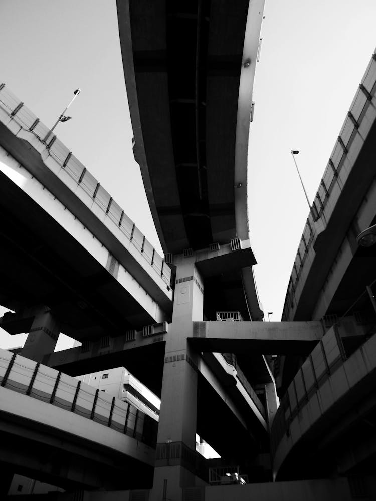 Black And White Shot Of Street And Bridges Crossing Overhead