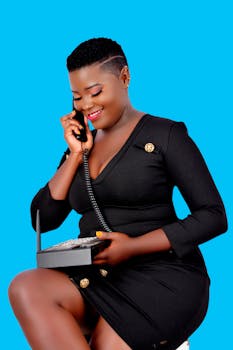 Stylish woman in business attire having a cheerful phone conversation.