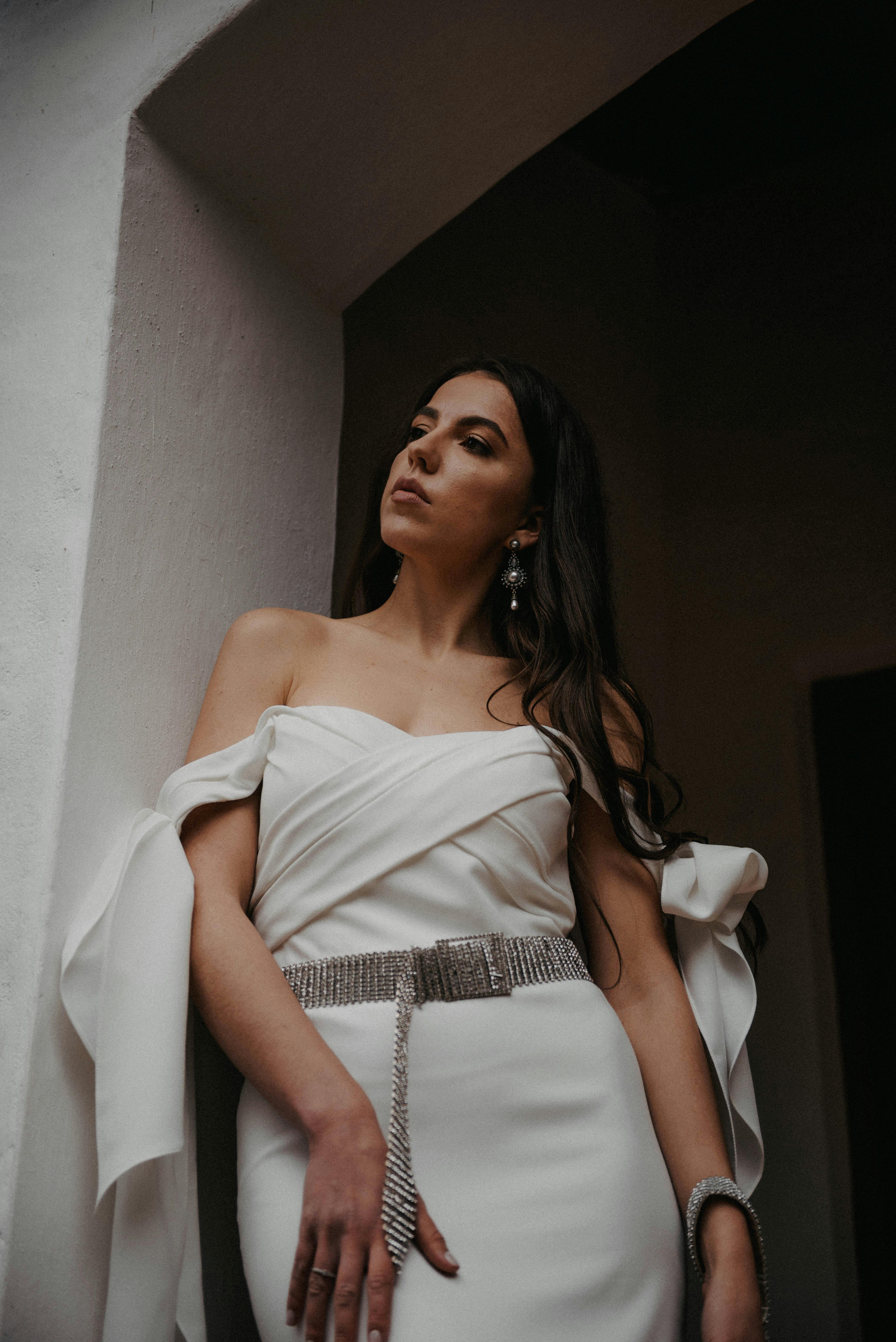 一位穿着优雅露肩白色连衣裙的女士别致肖像，展现了时尚与优雅