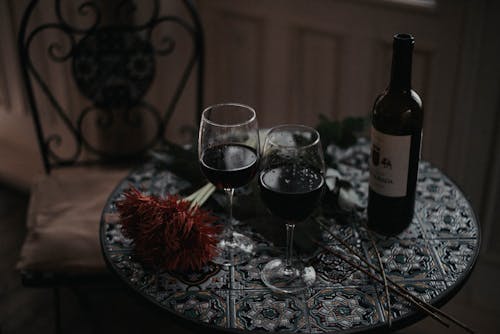 Two Glasses of Red Wine and a Bottle on a Round Table