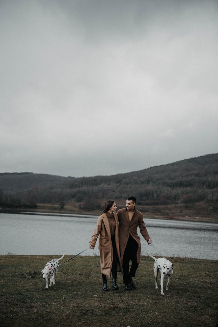 Couple With Dogs On Leashes