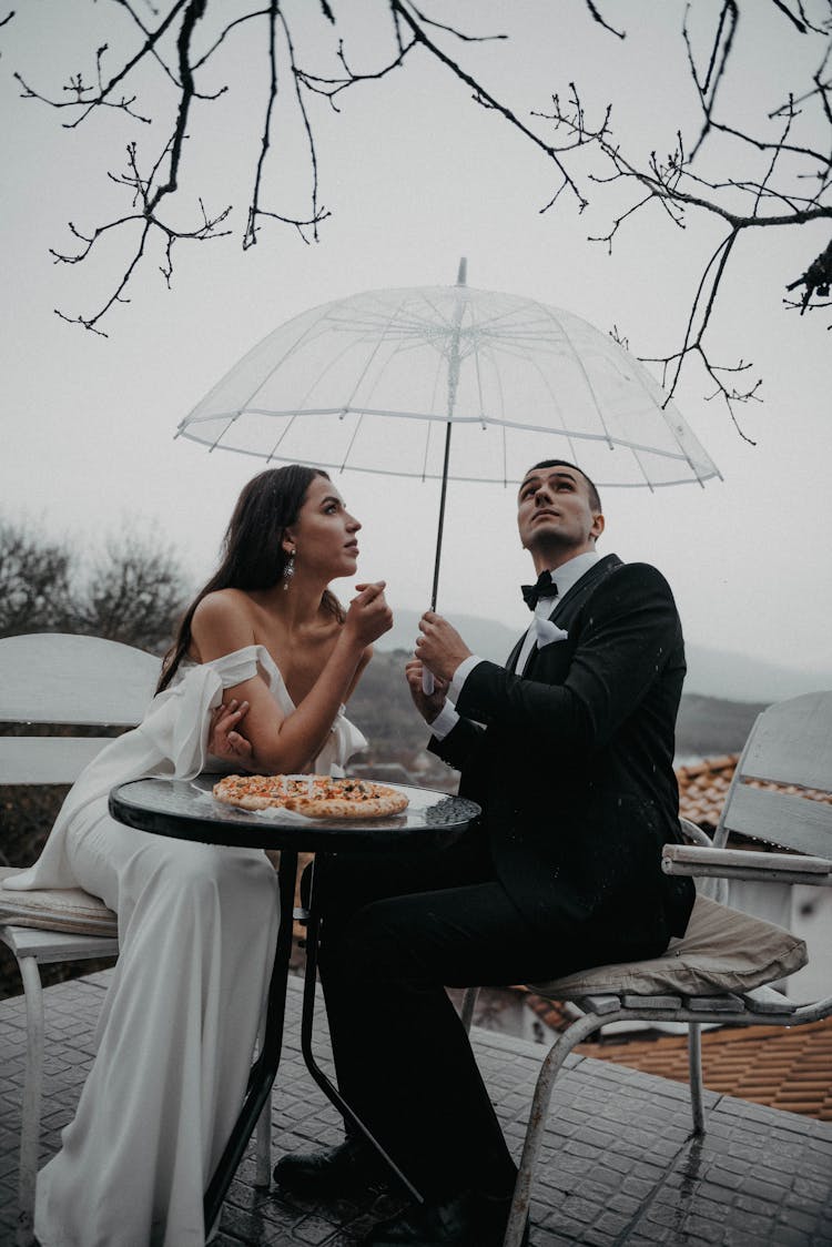 Man Holding An Umbrella Over A Woman