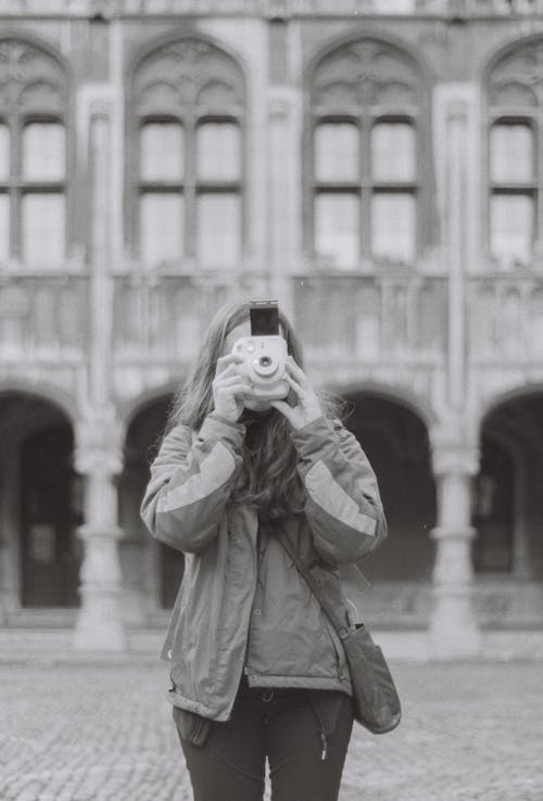 Free A Woman Using a Polaroid Camera Stock Photo