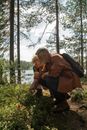 Grandfather and Grandson Picking Blueberries in a Forest