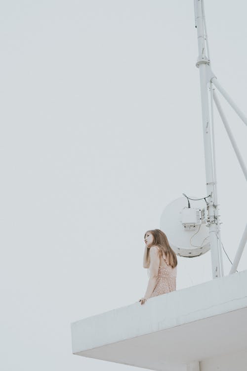 Free Woman in White Tank Top Standing on White Metal Ladder Stock Photo