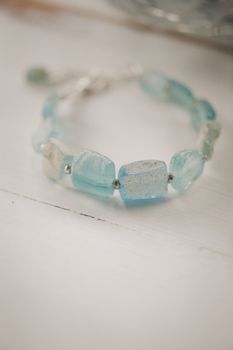 A delicate blue crystal bracelet with silver accents on a white surface, perfect for fashion enthusiasts.