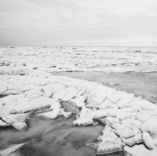 Grayscale Photo of Broken Ice on Body of Water
