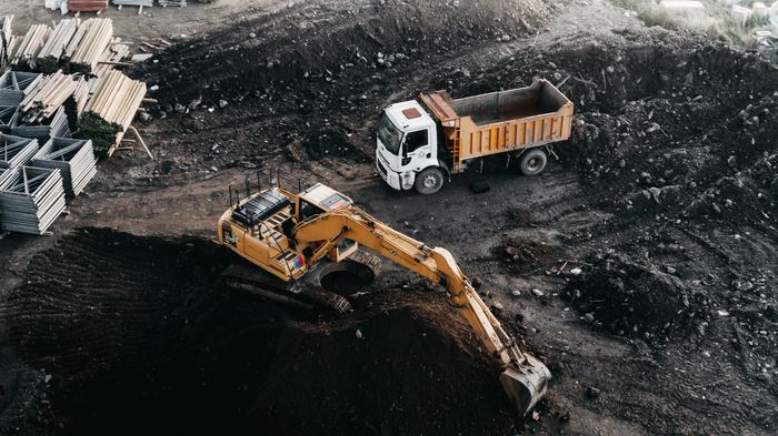 Excavator loading a dump truck at an industrial construction site