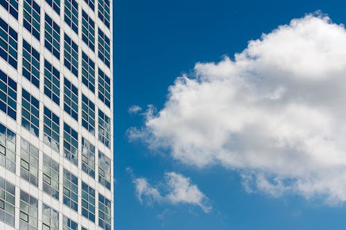 Facade of a Modern Building in City against Blue Sky with White Clouds