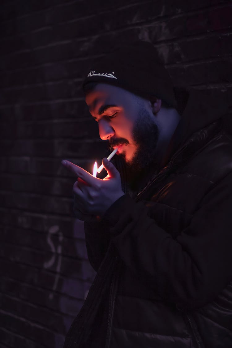 A Man Smoking A Cigarette Wearing Black Knit Cap