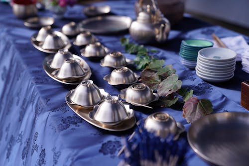 Free An Arrangement of Stainless Tableware  on a Table with  Blue Cover Stock Photo