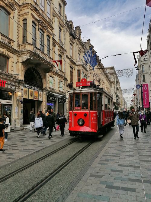 Free Iconic red tram traveling along the bustling İstiklal Avenue in İstanbul, Turkey. Stock Photo