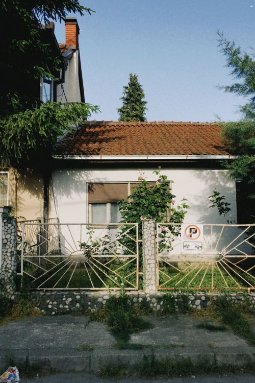 Free Exterior view of a Skopje house with a decorative fence and greenery. Stock Photo