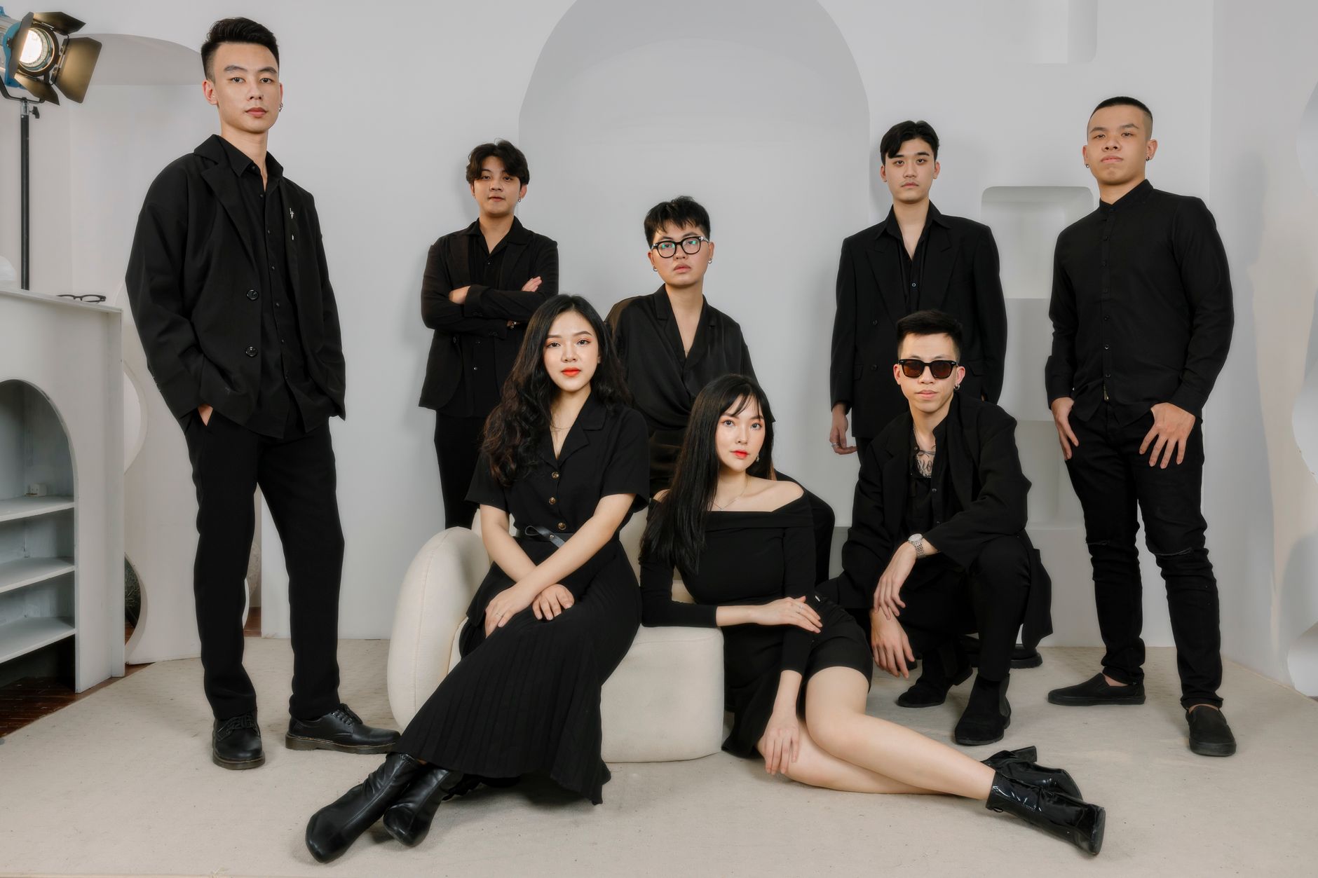 Trendy group portrait with black outfits, showcasing modern style and unity indoors.