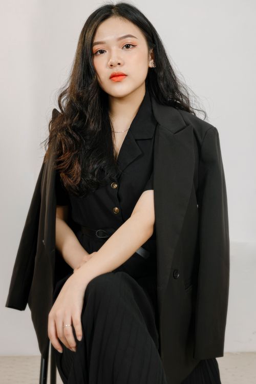 Free Stylish portrait of a woman wearing a black suit exuding elegance and confidence, ideal for fashion shoots. Stock Photo