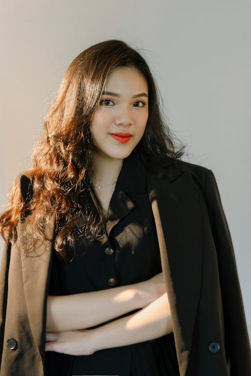 A Woman Draping  Black Blazer Over her Shoulders