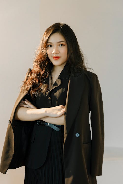 A Woman Draping Black Blazer Over her Shoulders
