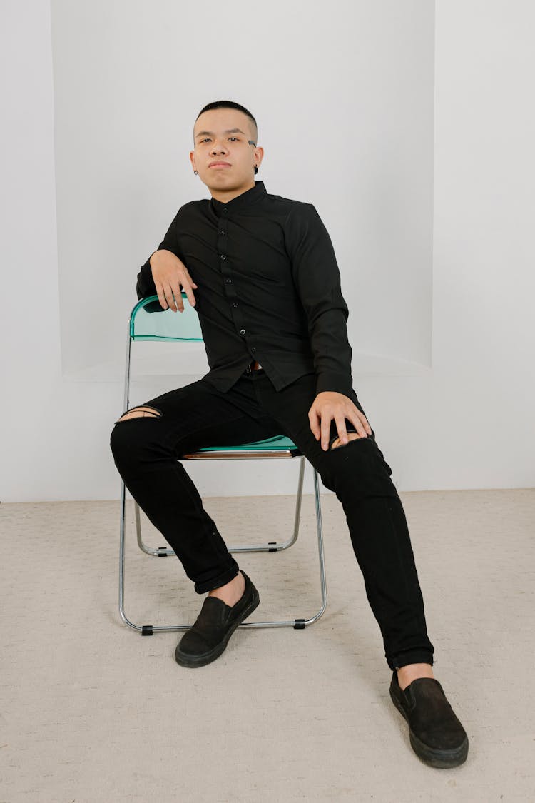 A Man In Black Shirt Sitting On A Chair