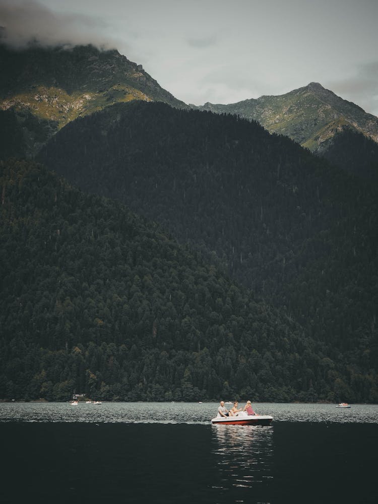 Pedal Boat Sailing On Lake In Mountains