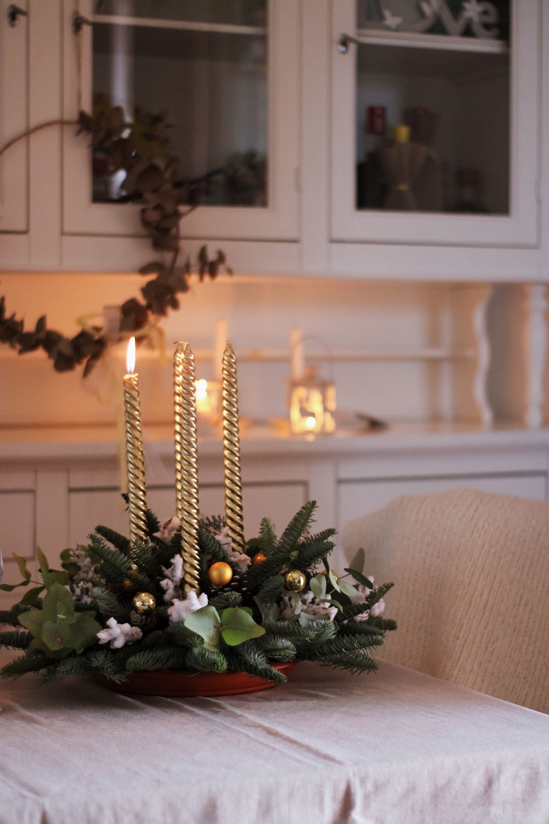Christmas greenery and candles arranged in a kitchen dining area