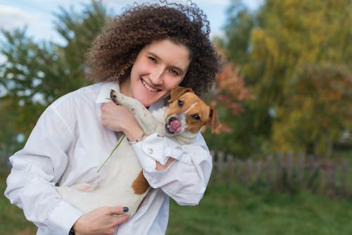 Woman with Curly Hair Holding a Dog
