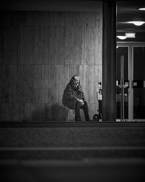 Elderly Woman sitting on a Stool on Streetside 
