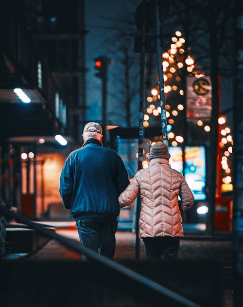 Free A Couple Wearing Winter Clothes while Walking on the Street Stock Photo