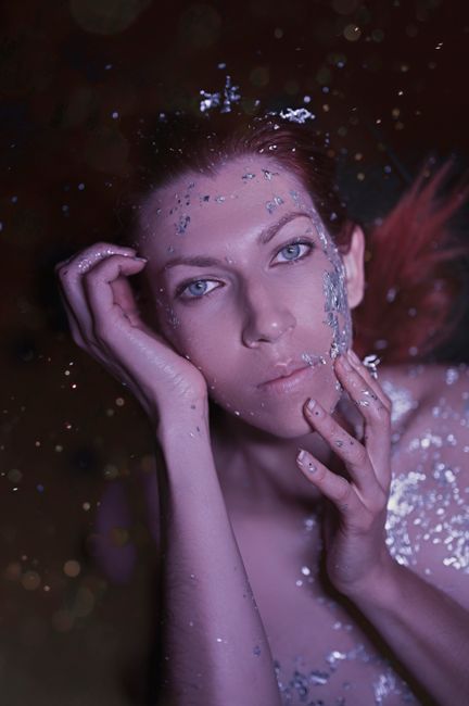 A mesmerizing portrait of a woman adorned with glitter, evoking a mystical vibe.