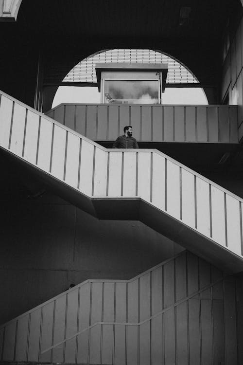 Free Monochrome Photo of Man standing on a Staircase Stock Photo
